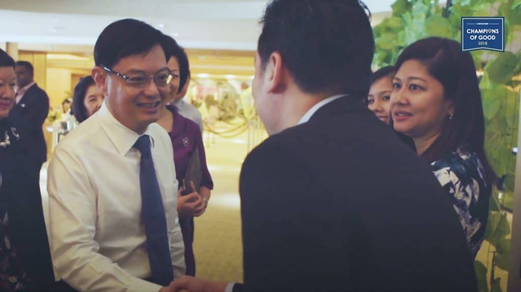 man in suit shaking hands with heng swee keat