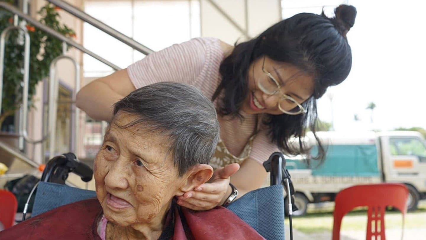 girl giving elderly lady a haircut