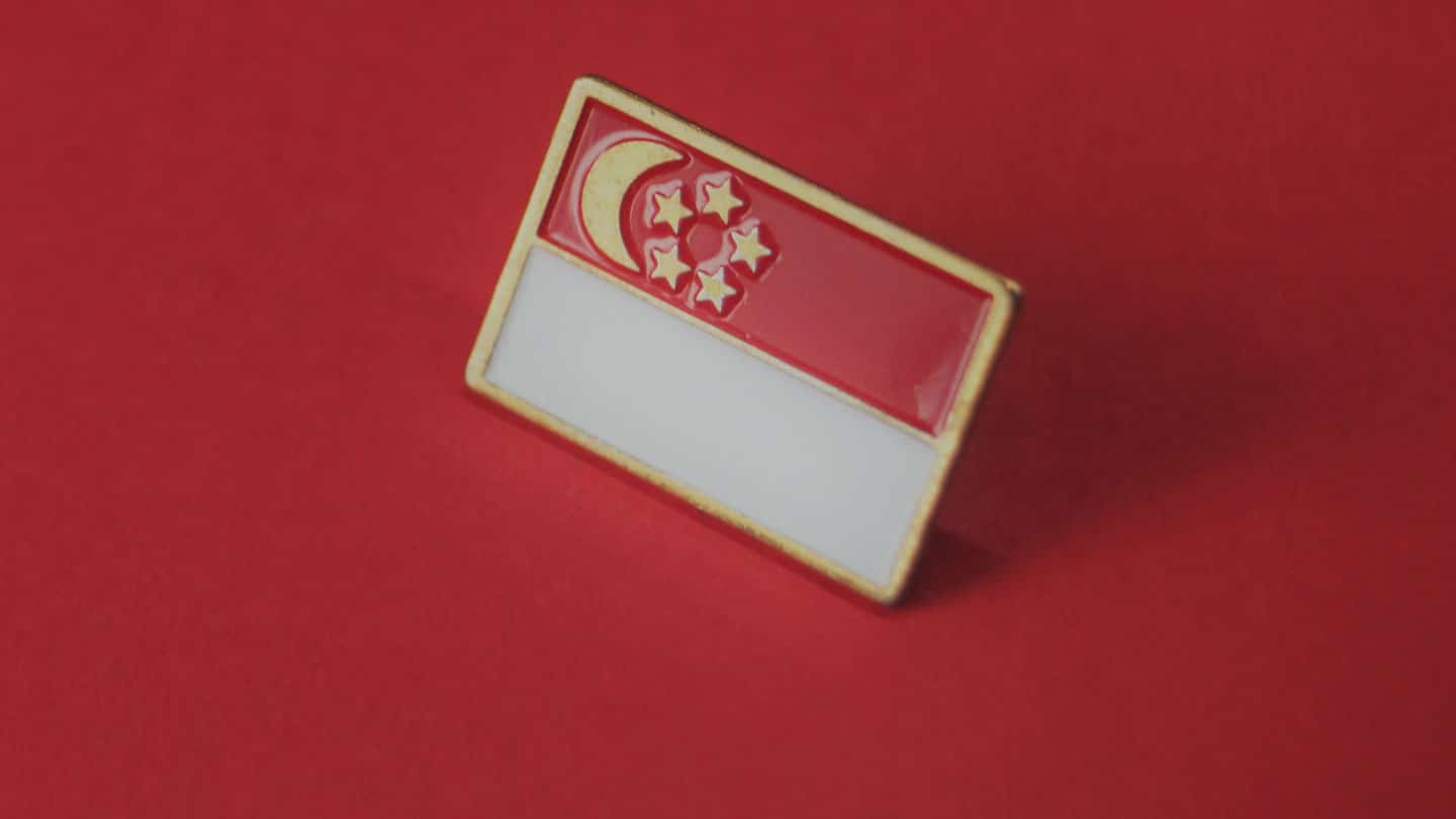 singapore flag enamel pin on red table