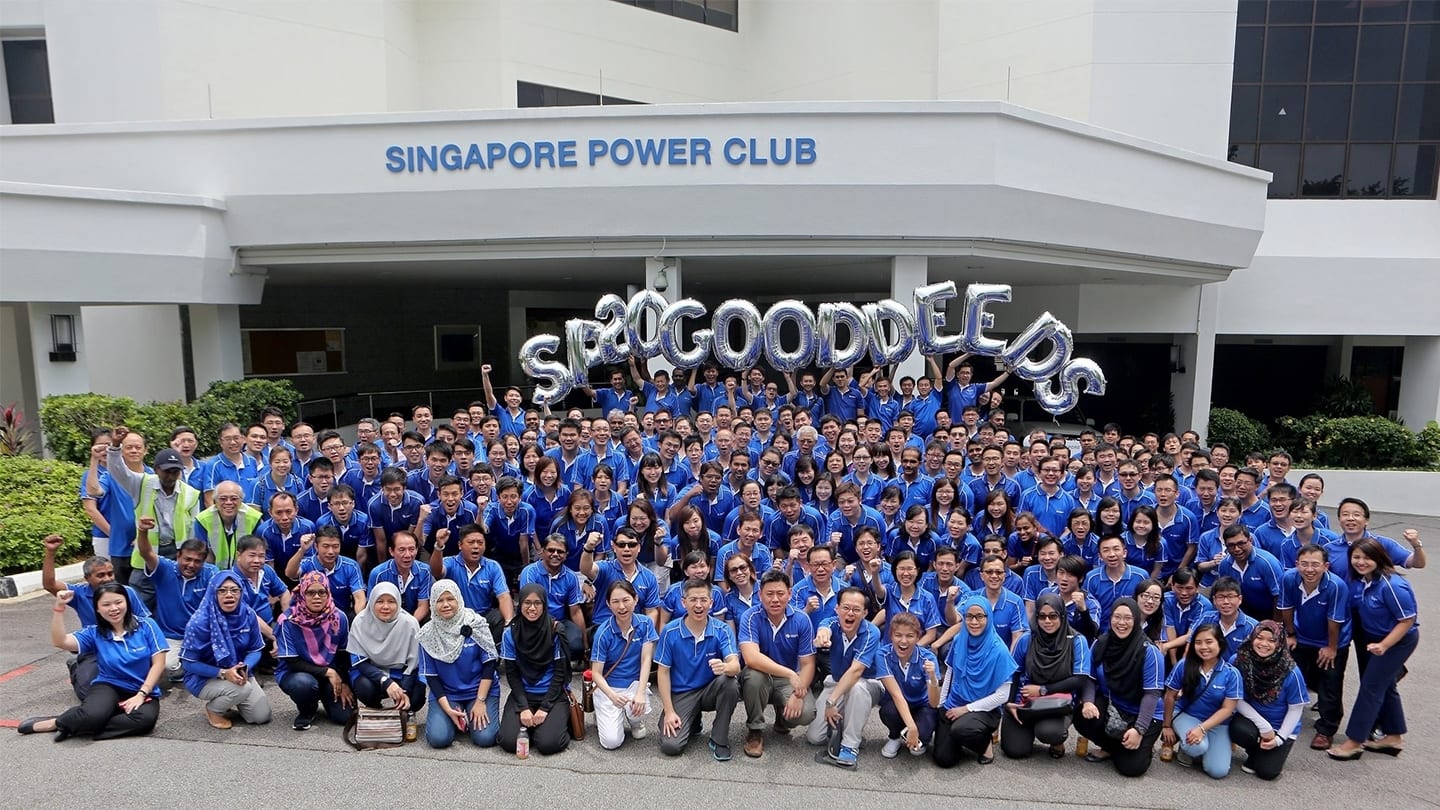 employees at singapore power club posing for group photo