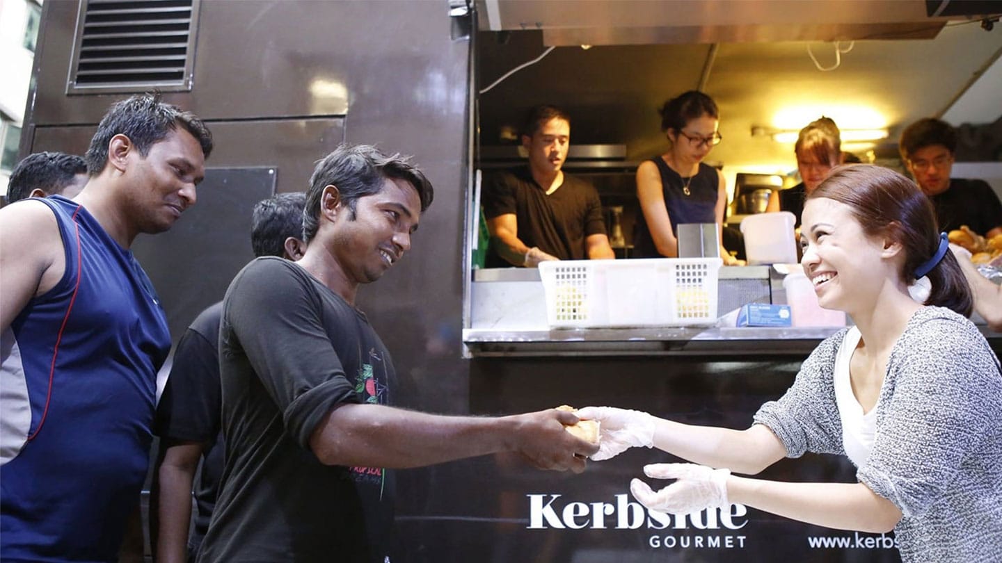 volunteers with kerbside gourmet handing out food to migrant workers