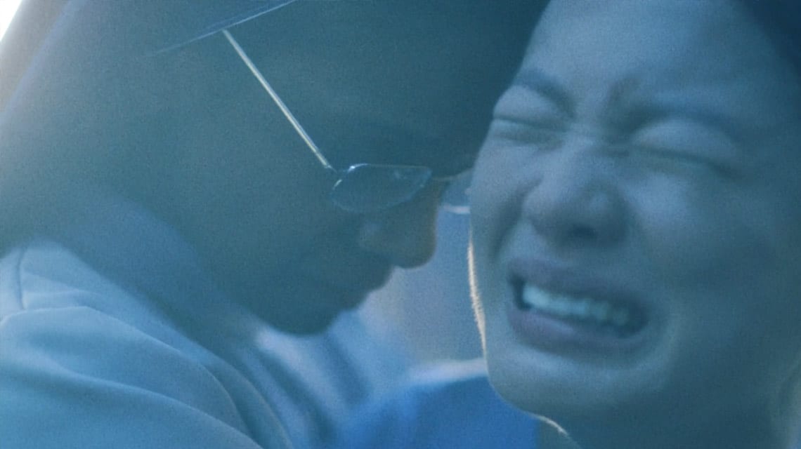 blue-tinted photo of indian woman in silver glasses hugging crying lady